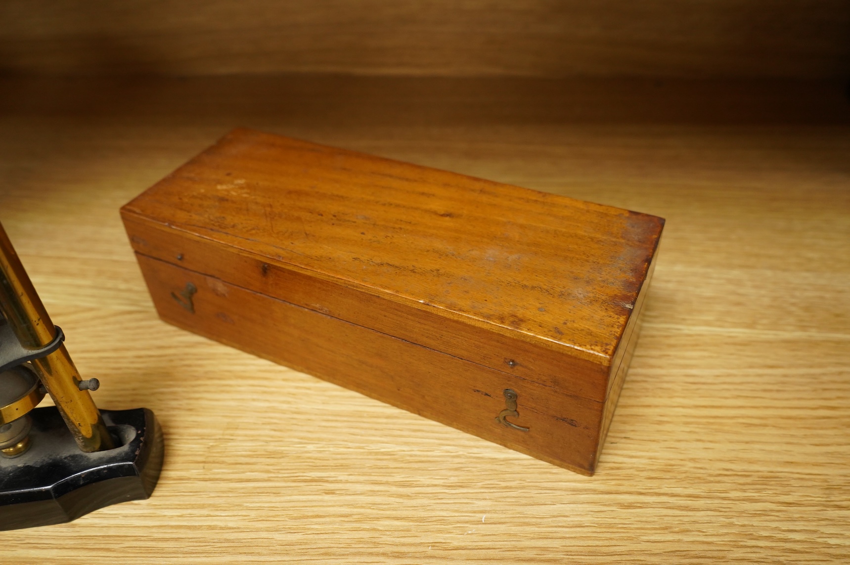 A late 19th/early 20th century French brass compound monocular microscope, height 20.5cms, together with a teak case; 23cm wide, 9cm deep, 7cm high